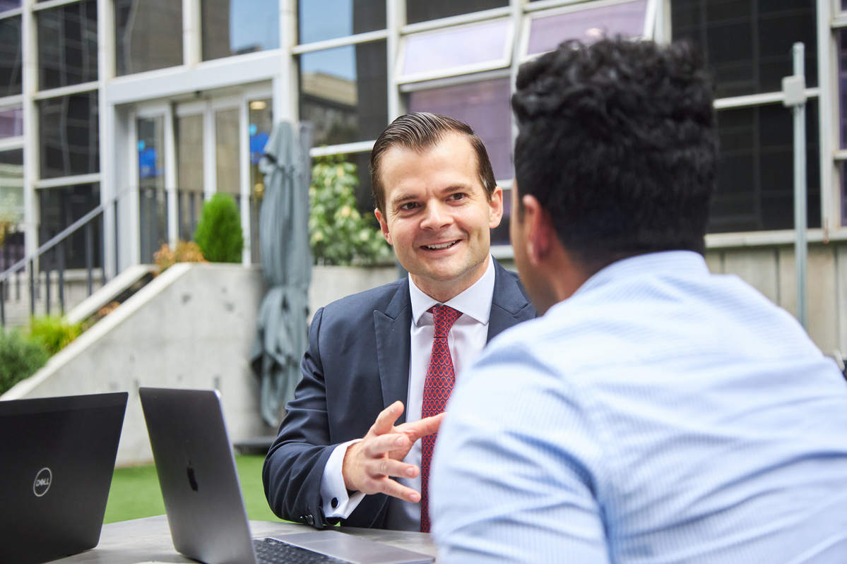 man in suit talking to another man