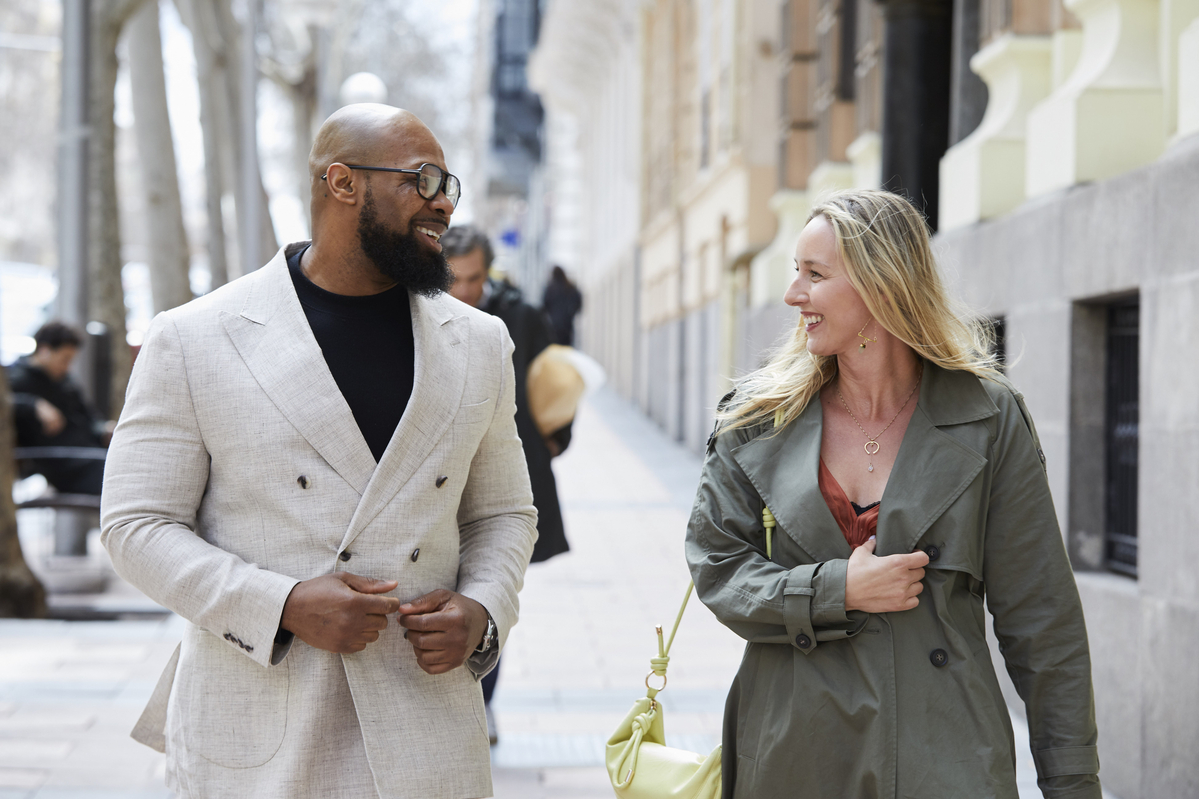 Man in suit walking and talking to woman