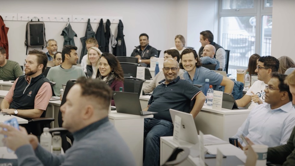 still of students smiling in a classroom from the video